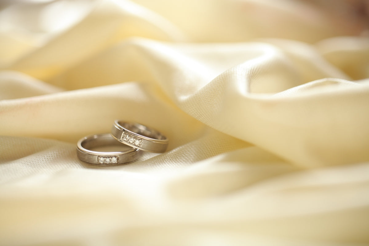 two silver-colored rings on beige textile