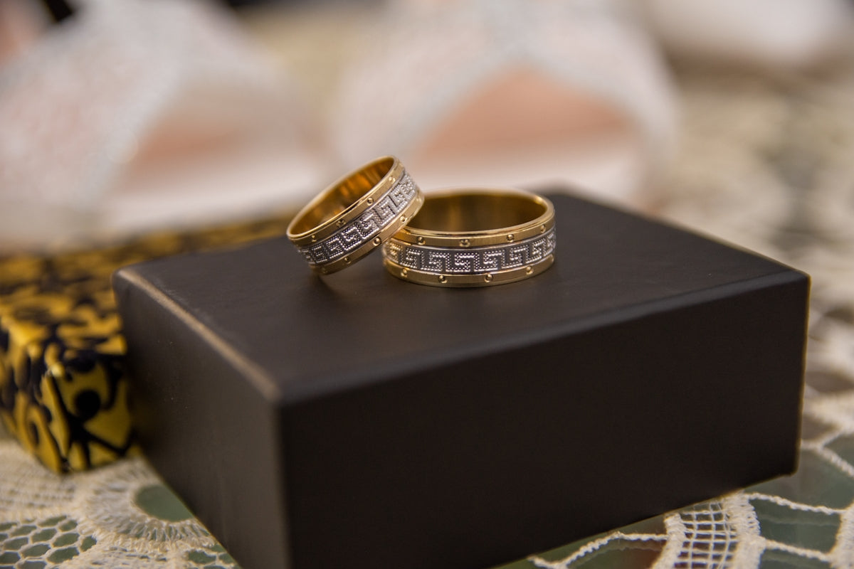 two wedding rings sitting on top of a black box