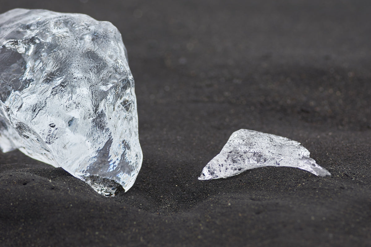 two pieces of ice on a black surface