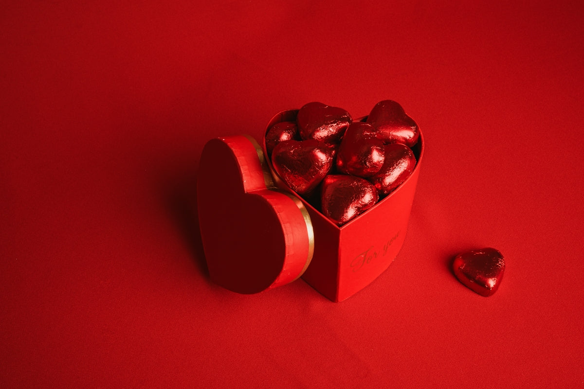 a heart shaped box of chocolates on a red background