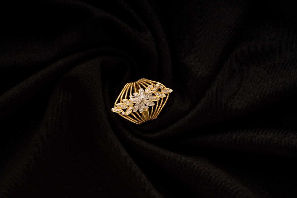 A gold ring sitting on top of a black cloth
