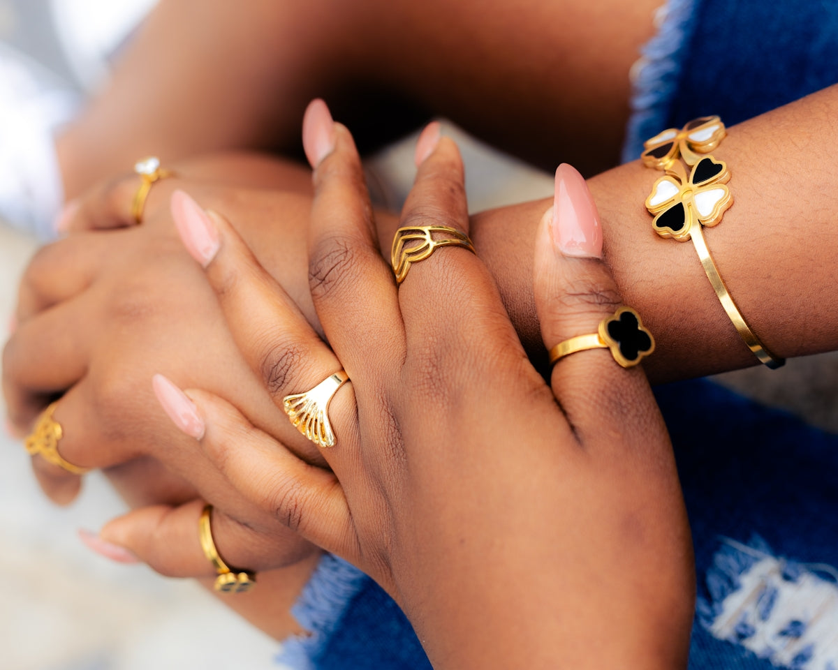 Hands adorned with gold jewelry.