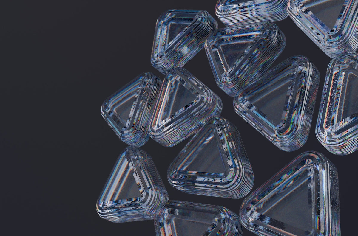 Clear, triangular shapes are scattered on a dark surface.