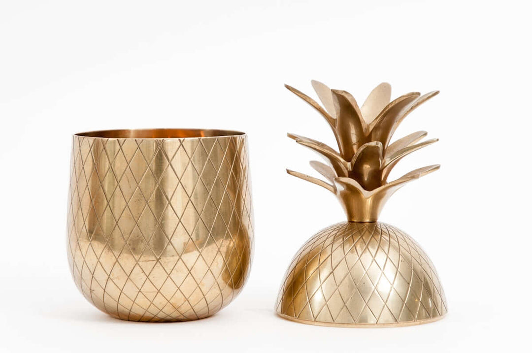 Stijlvol gouden ananan-vormig decoratief item en bijpassende beker met een geometrisch patroon.
