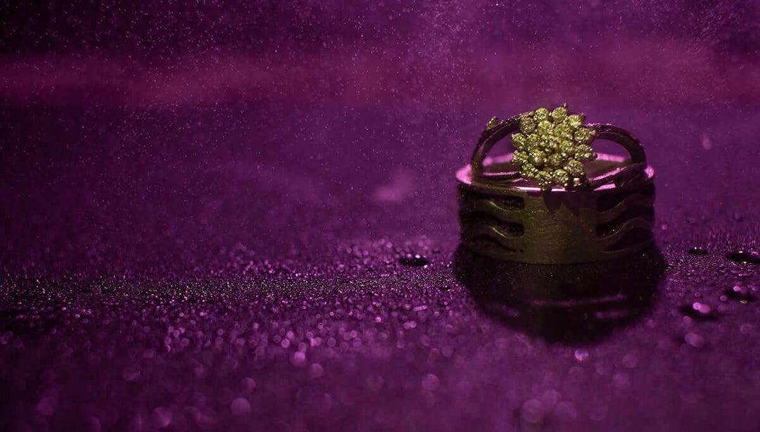 Emerald Solitaire diamanten ring op een nat oppervlak met paarse verlichting, presentatie van elegantie en luxe van Lucellia.
