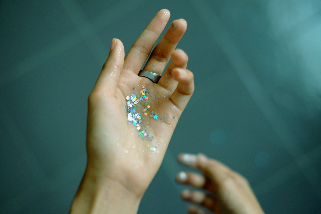 persona che mostra le mani con glitter