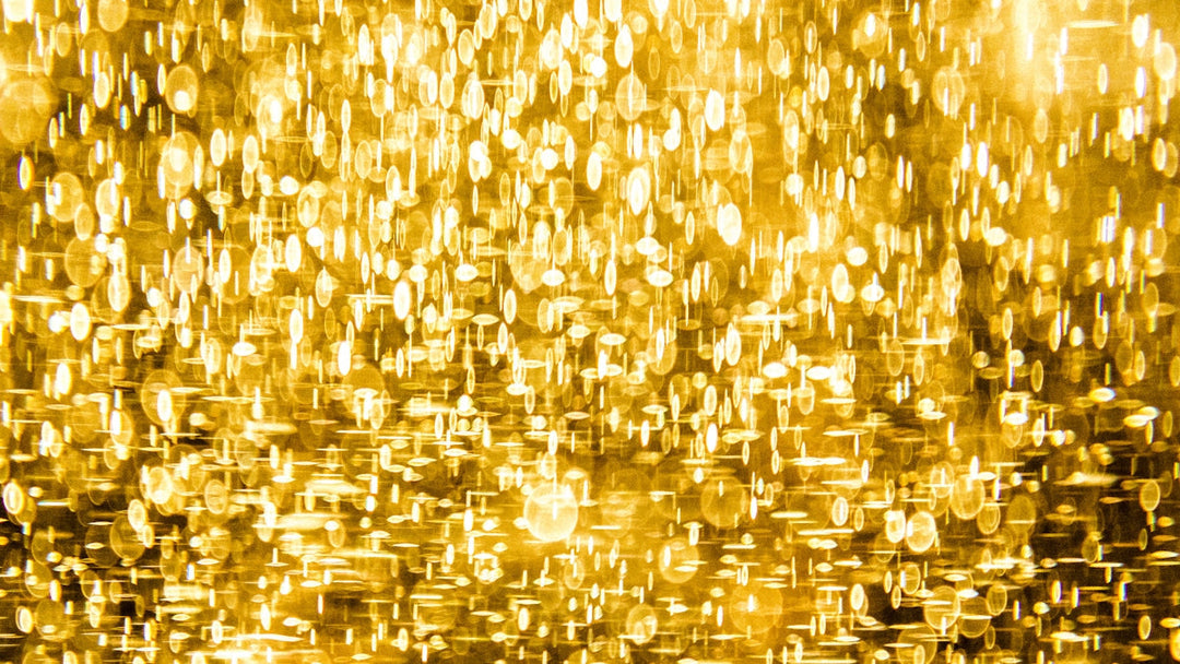 Snalde gouden achtergrond met sprankelende lichten, waardoor een elegante en luxueuze ambiance wordt gecreëerd.