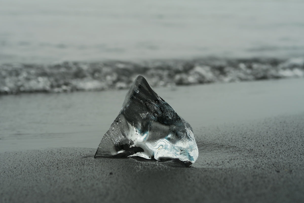 Fotografia in scala di grigi di Glass Shard by the Sea
