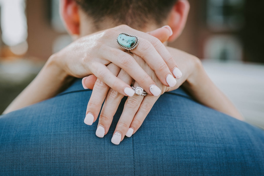 Person, die silberfarbene Ring und weißer Nagellack trägt