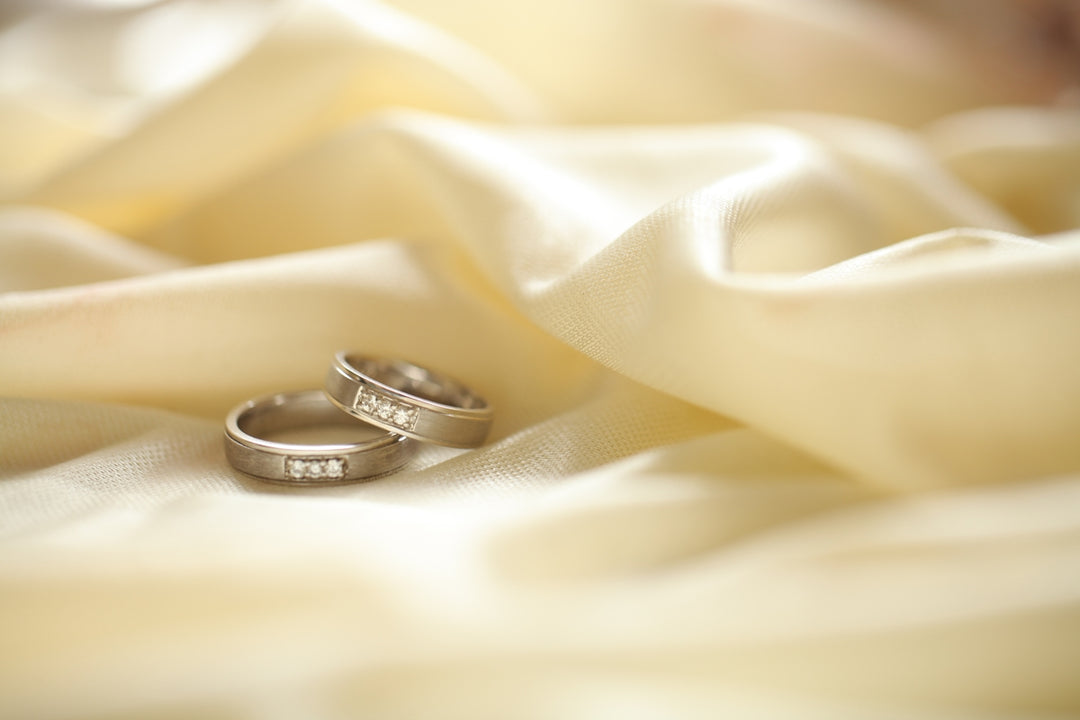 two silver-colored rings on beige textile
