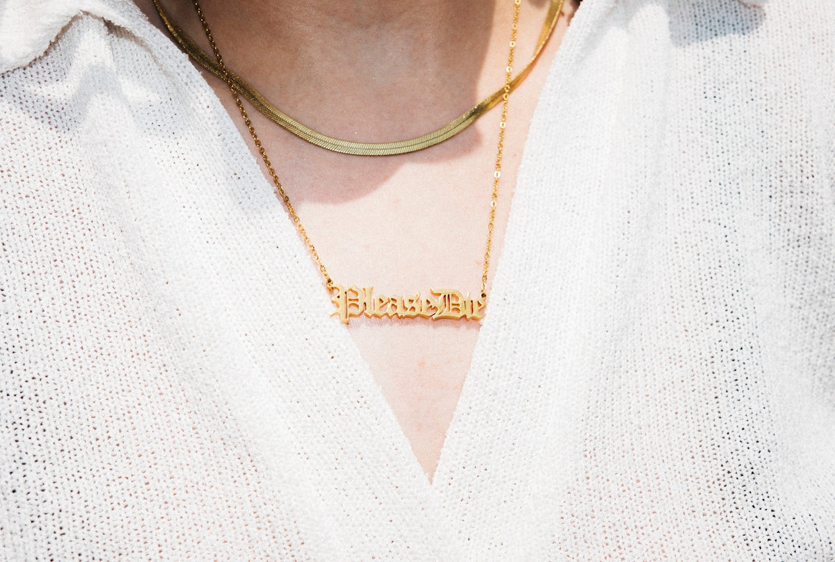 vrouw in witte V-hals blouse met gouden ketting
