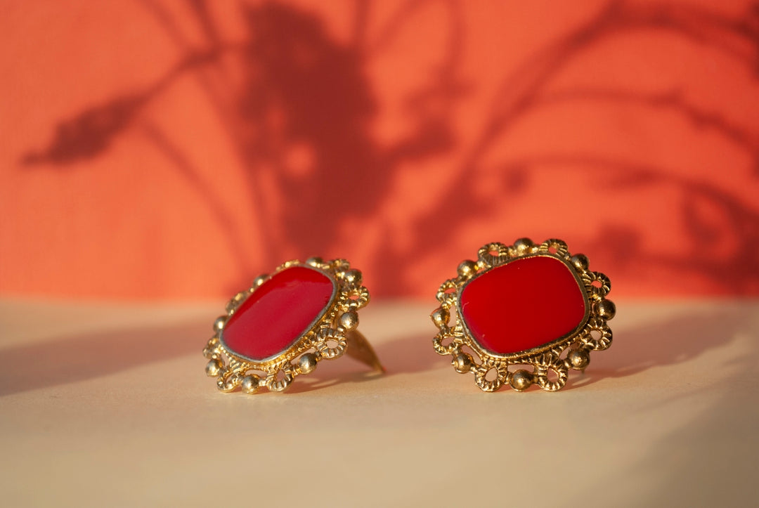 a pair of red earrings sitting on top of a table