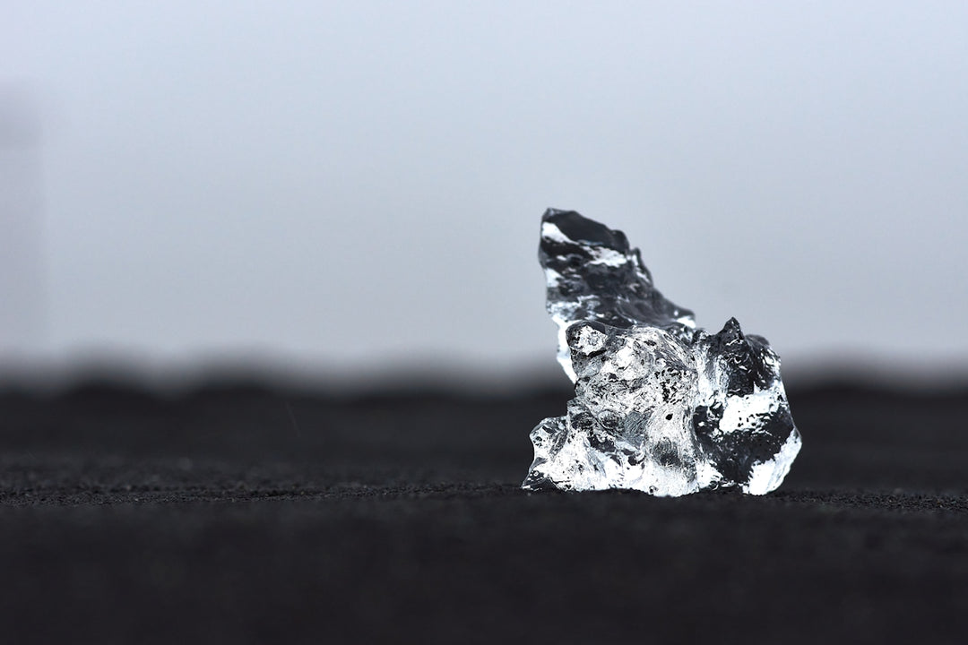 a piece of ice sitting on top of a black surface