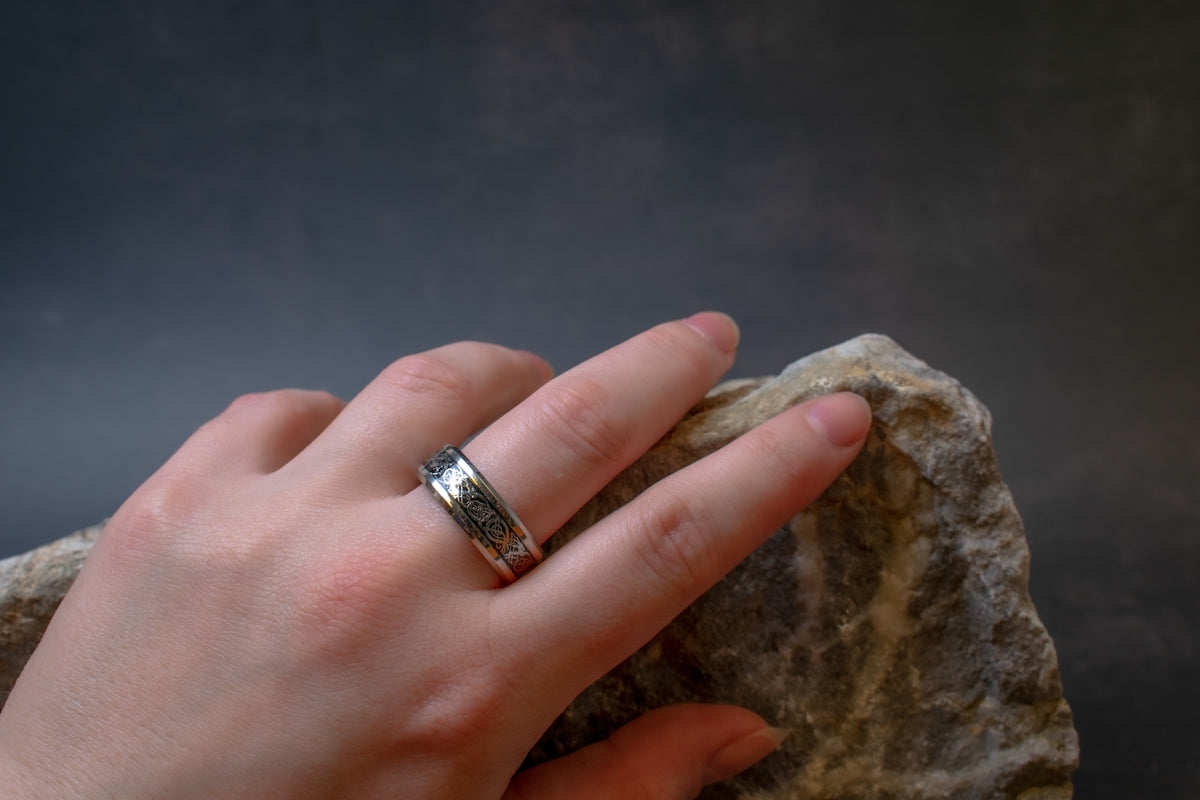 a woman's hand with a ring on top of a rock
