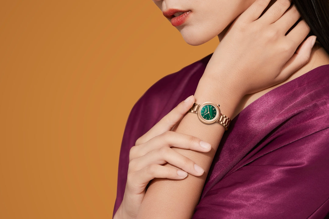 una donna che indossa un anello con una pietra verde sopra