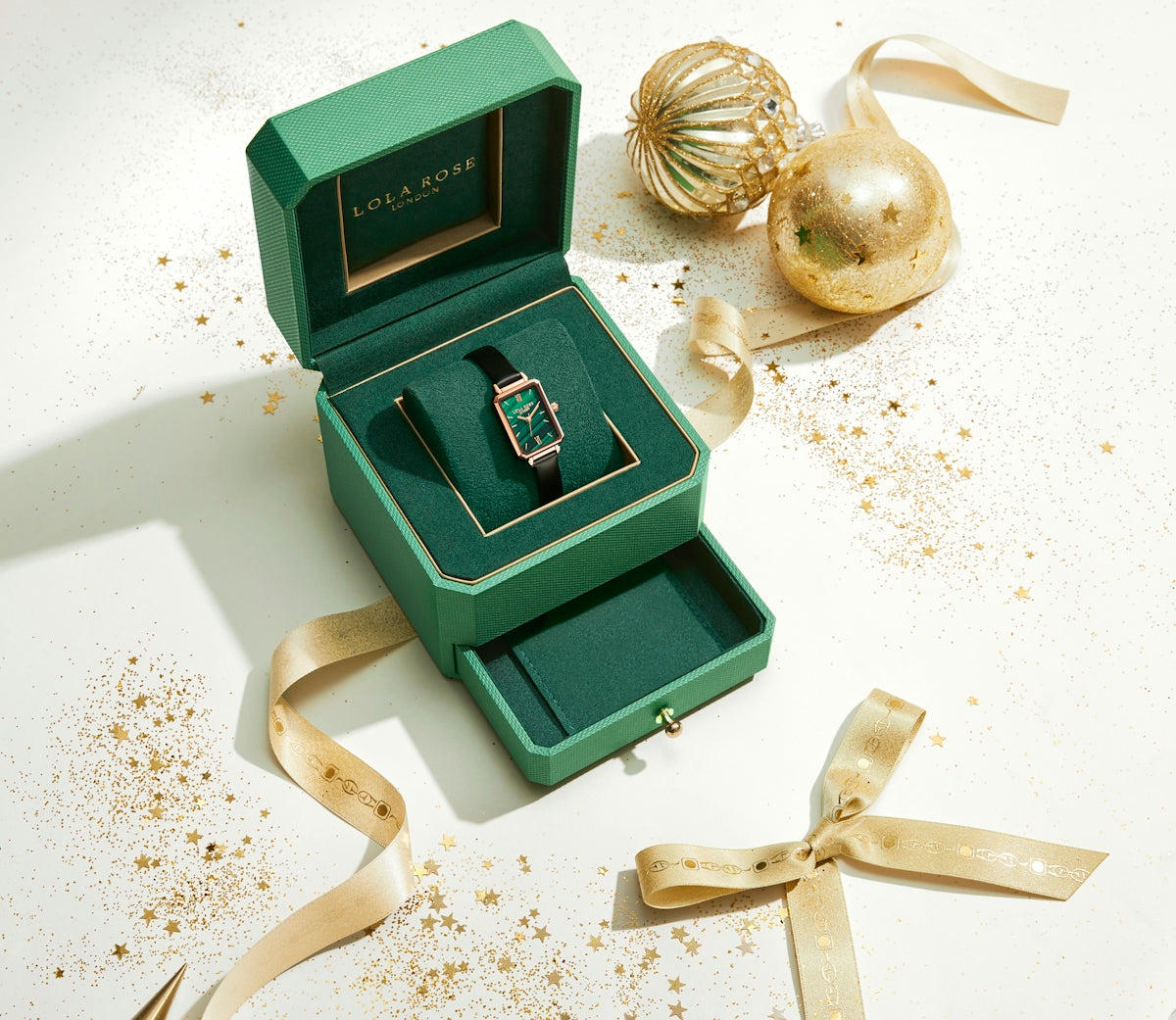 a green and gold object with a key and a key on a white surface