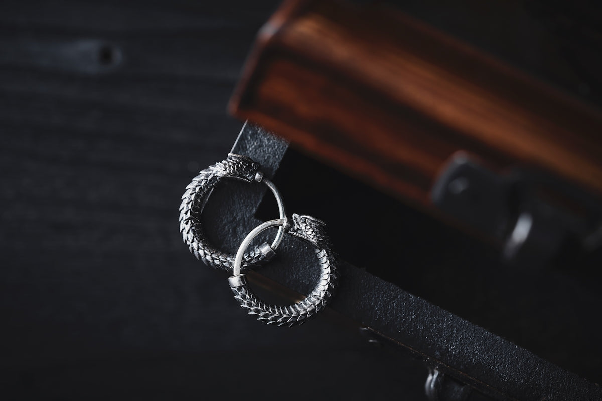 a pair of silver rings sitting on top of a black leather belt