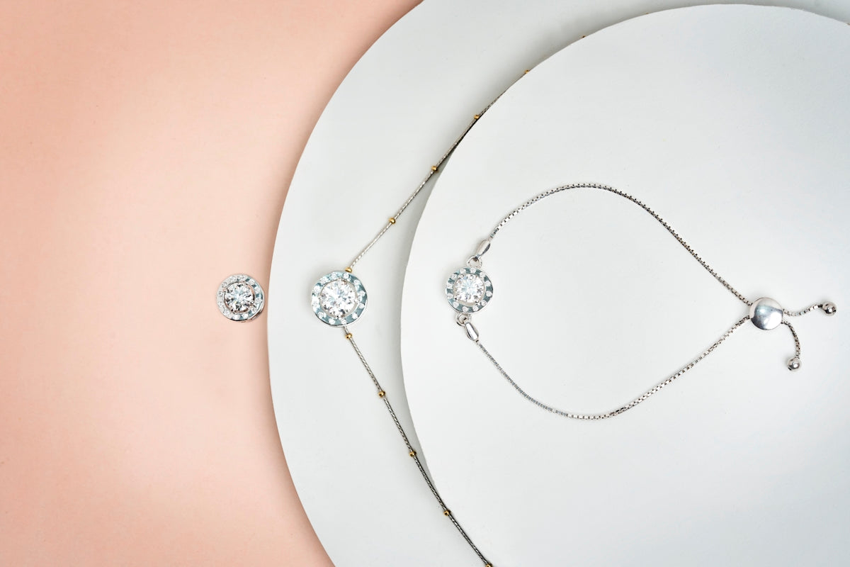 a white plate topped with a necklace and a pair of earrings
