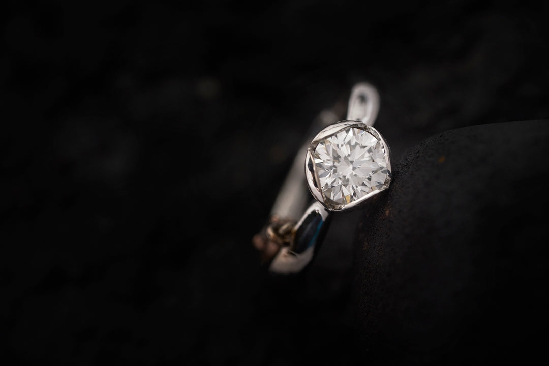 a close up of a diamond ring on a black surface