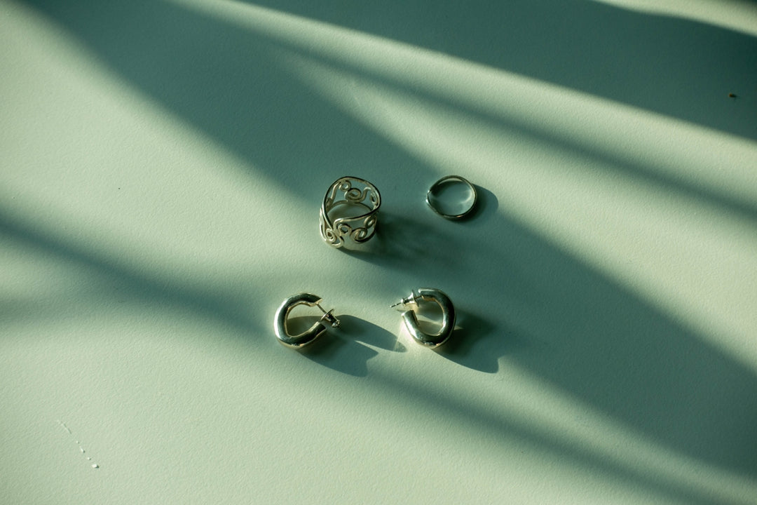 three pairs of earrings sitting on a table