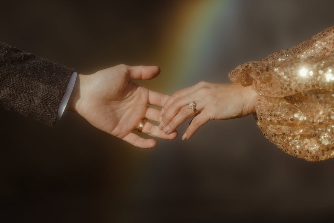 Un uomo e una donna si tengono per mano con un arcobaleno sullo sfondo
