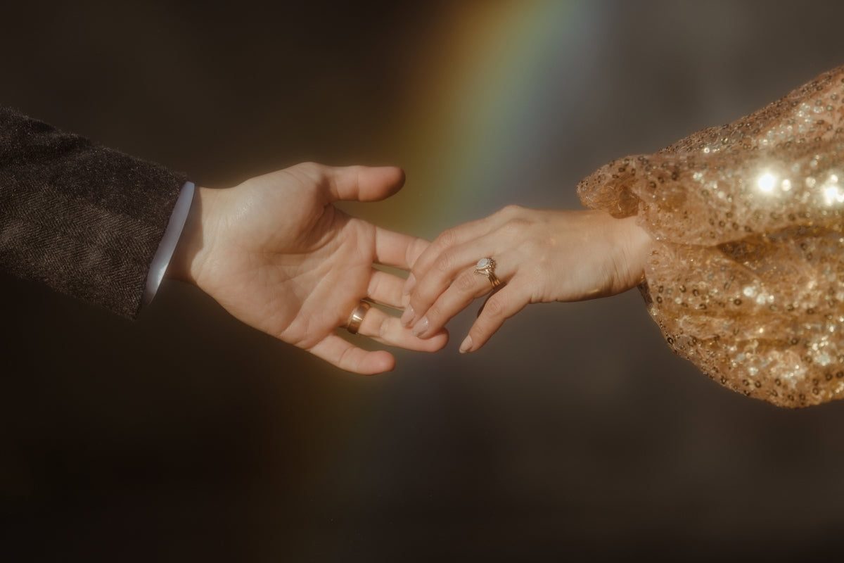 Un uomo e una donna si tengono per mano con un arcobaleno sullo sfondo