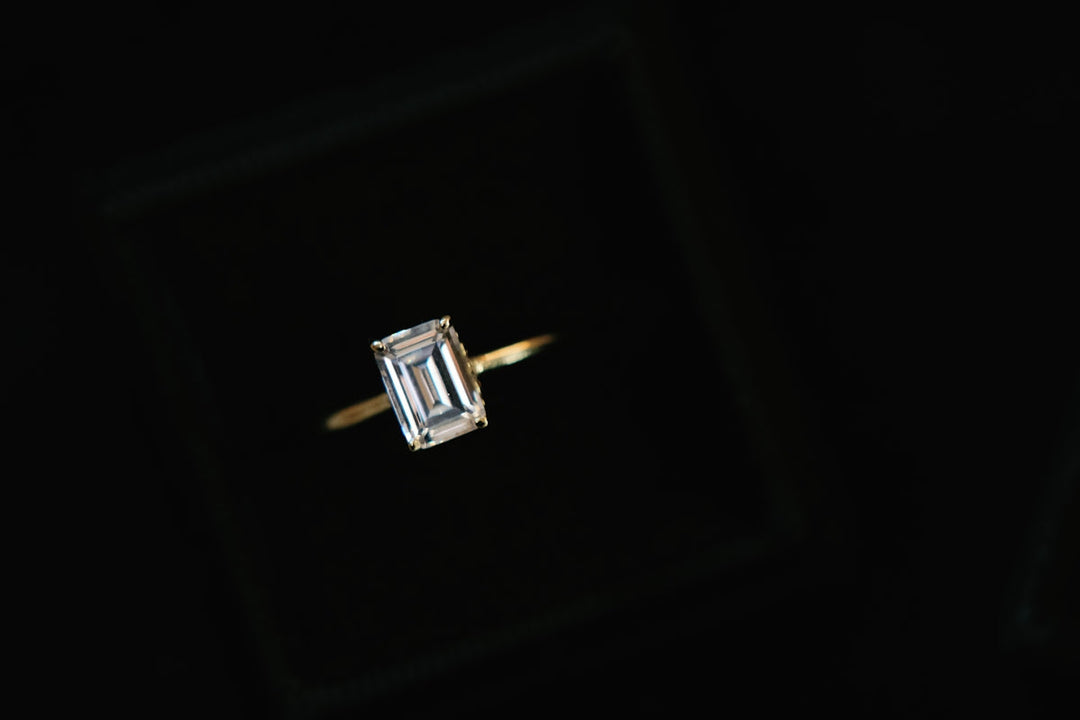 un primo piano di un anello di diamanti su uno sfondo nero