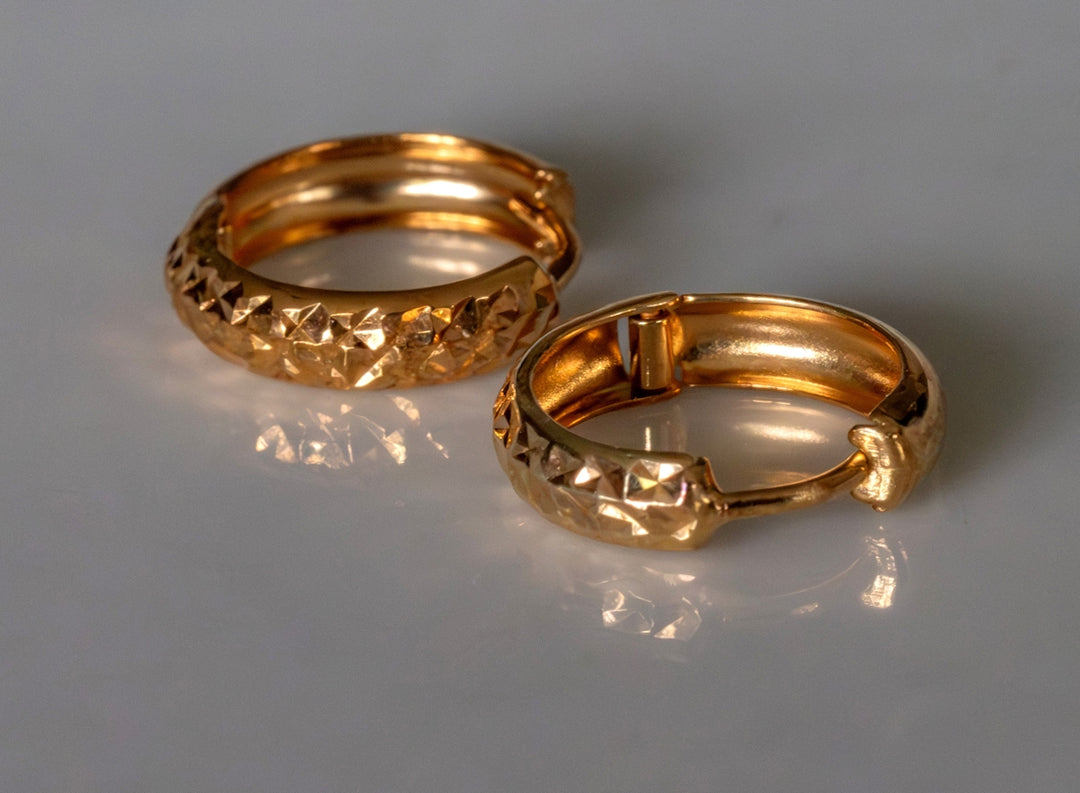 two gold rings sitting on top of a table