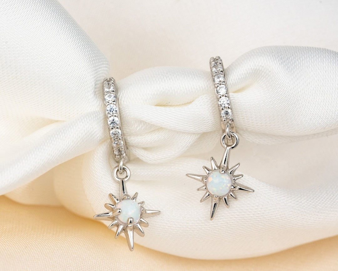 A pair of earrings sitting on top of a white cloth