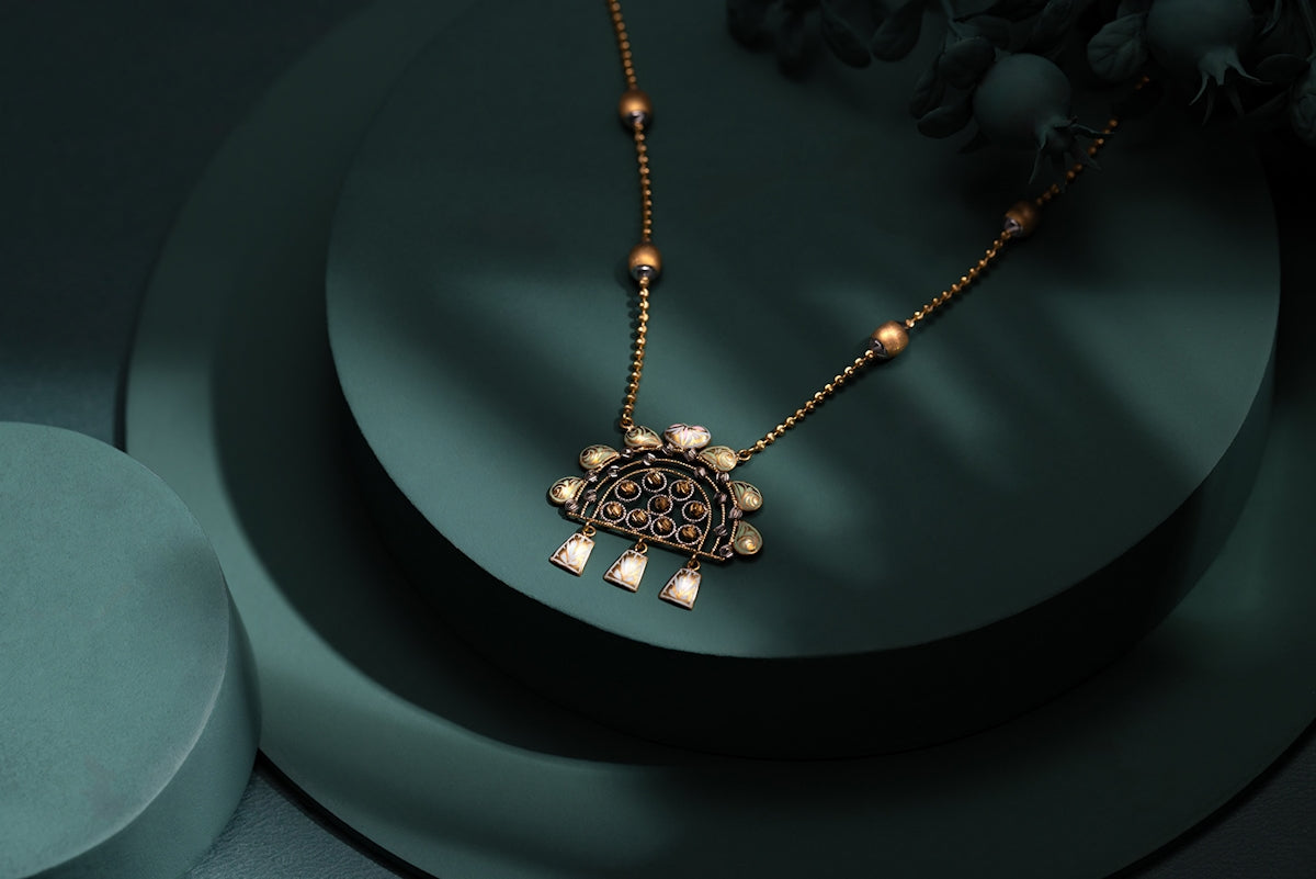 A necklace with a turtle on it sitting on a table
