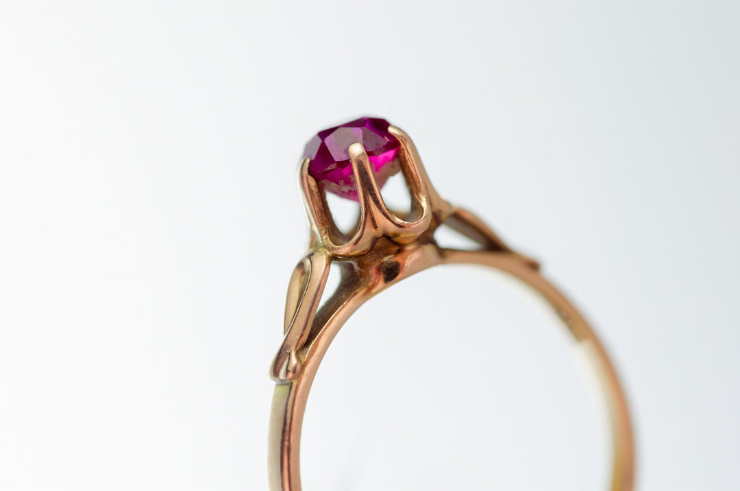 A close up of a ring with a pink stone