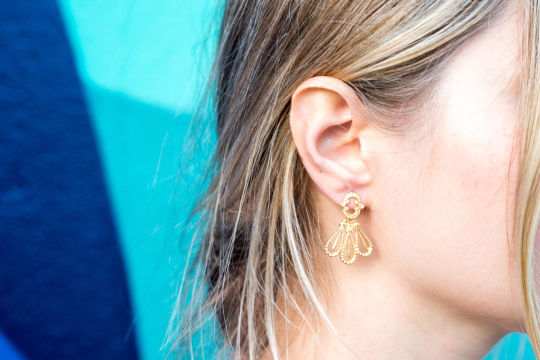 A close up of a person wearing a pair of earrings