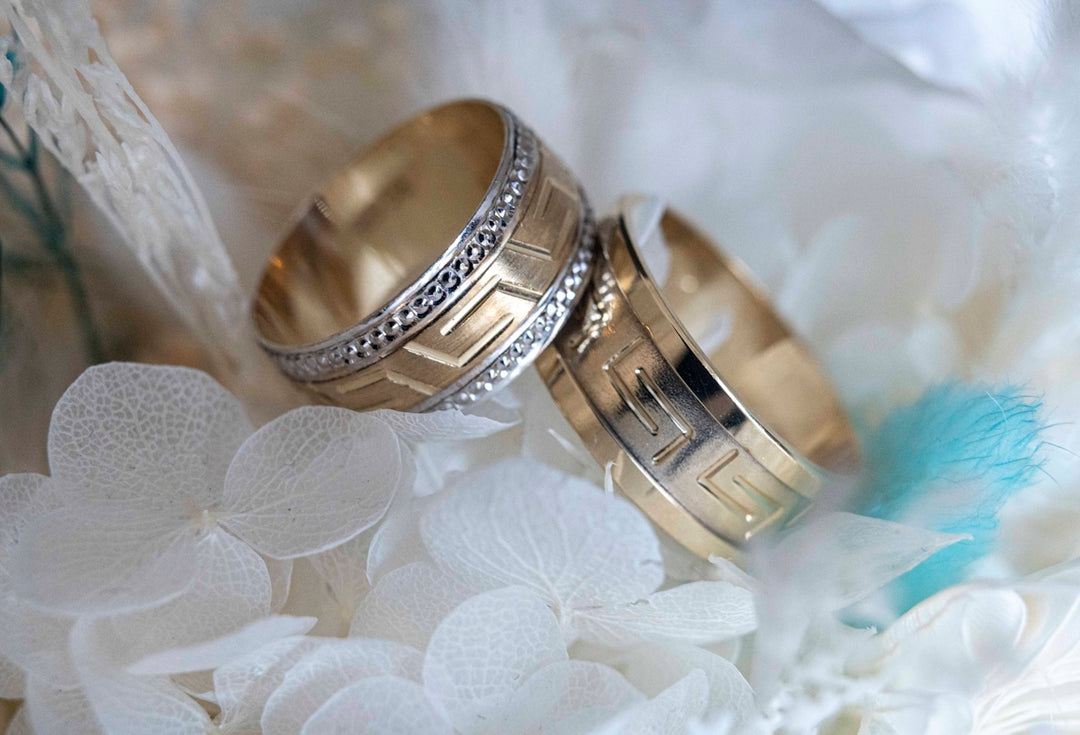 Two wedding rings sitting on top of a bouquet of flowers