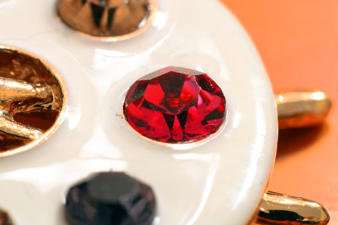 A close up of a white plate with different colored stones on it
