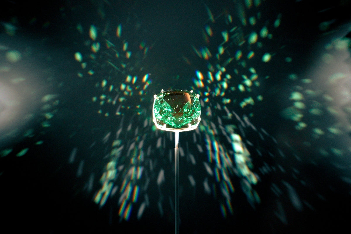 A green gem is showcased with a dark background.