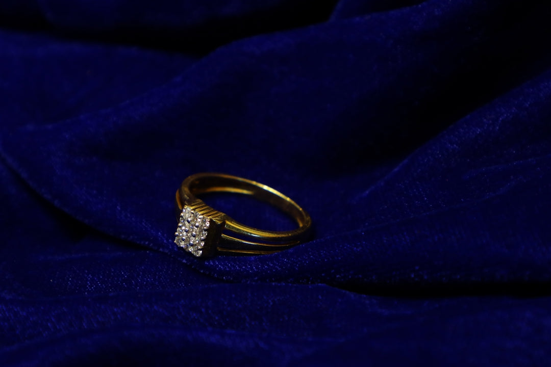 Gold ring with diamonds on blue fabric